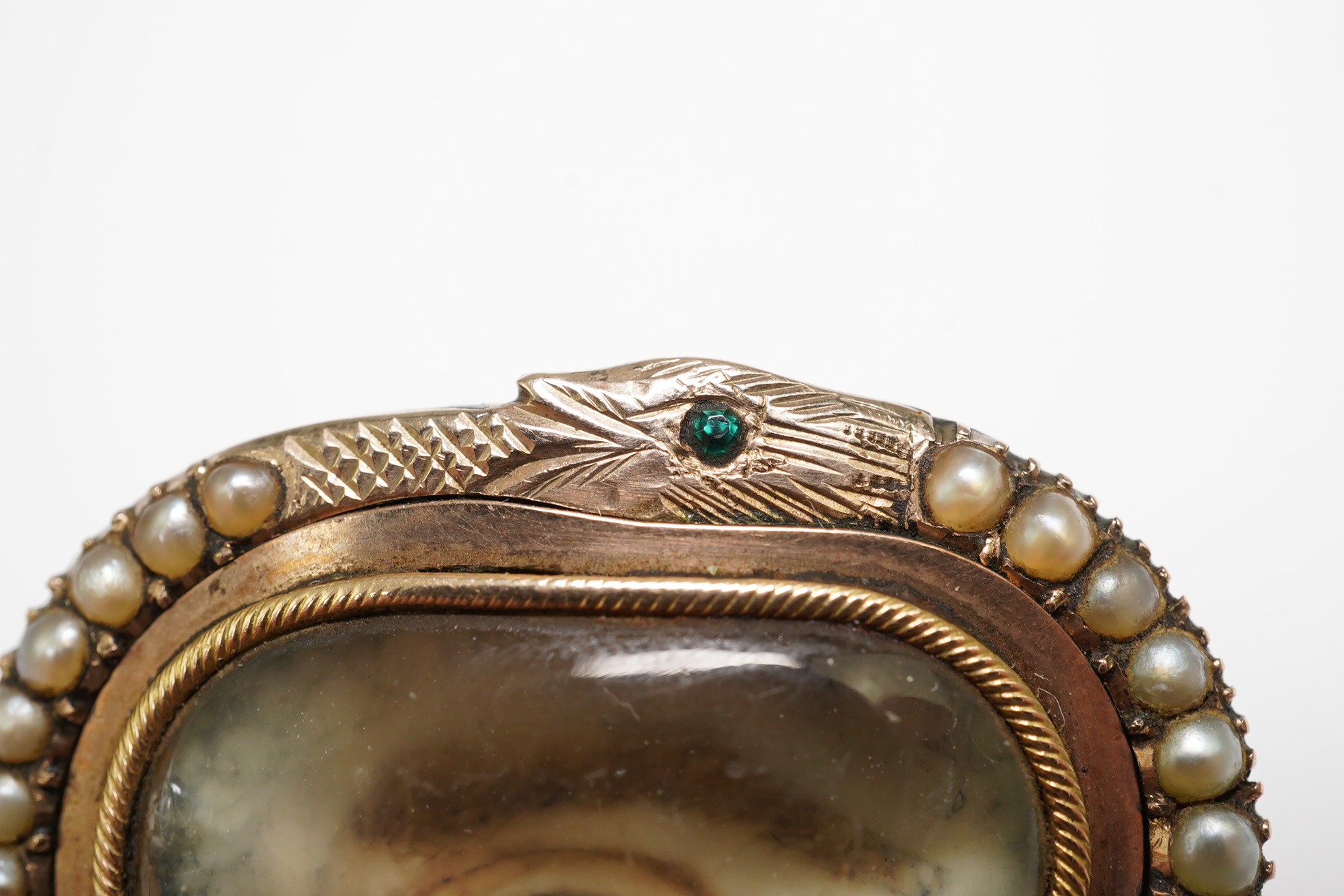 A Regency gold and split pearl mounted oval pendant brooch with inset 'lover's eye' miniature